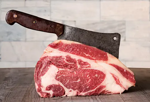 carne de vaca con grasa siendo cortada por un cuchillo